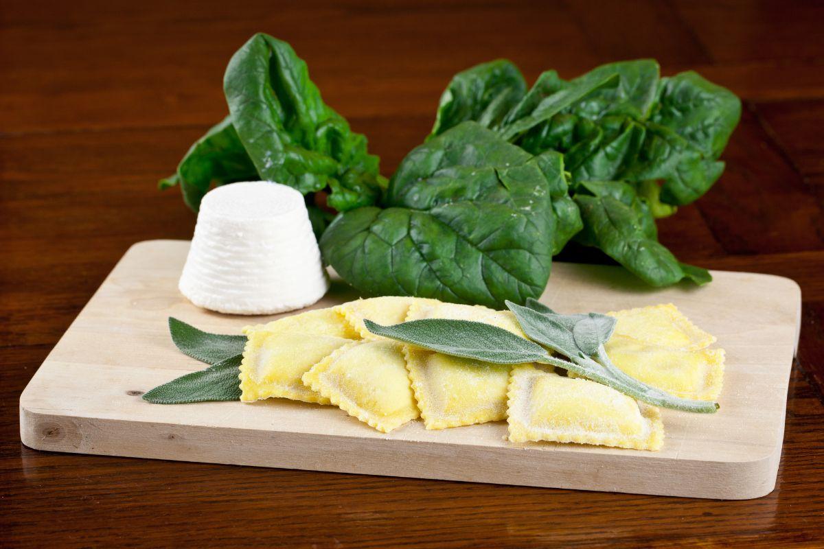 Ravioli ricotta e spinaci su un tagliere di legno